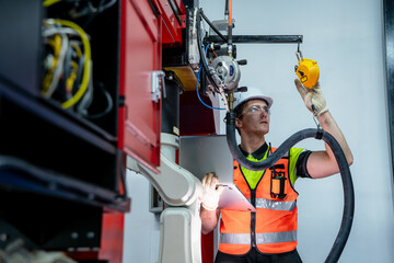 A man in a yellow vest is working on a machine. Concept of Industry 4.0 with diverse engineers collaborating on automation technology.