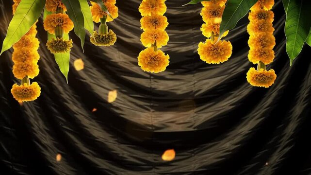Luminous yellow marigold garlands with mango leaves hang against a dark, textured background.