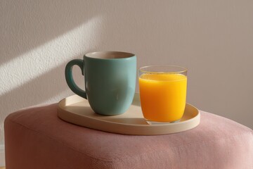 Vintage breakfast tray on pink ottoman teal mug orange juice glass in crisp depth focus side-lit with soft shadow