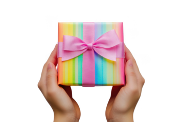 Hands holding a colorful striped gift box tied with a pink ribbon and bow isolated on transparent background