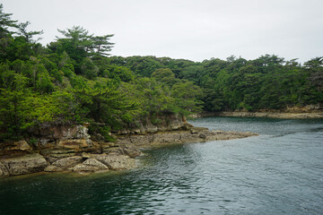 Nearby rocky coast of an island on the Japanese coast in the Saikai National Park's Kujukushima Islands, also called the 99 Islands, near Sasebo, Japan, as seen from the water