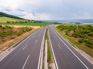 Straight empty D1 highway in rural Slovakia near Spišský Hrhov. Green fields, hills and cloudy...