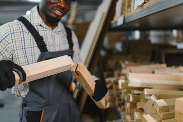African american Carpenter joining wooden furniture parts in workshop