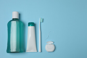 toothbrush, toothpaste, dental floss, tooth rinse on a blue background