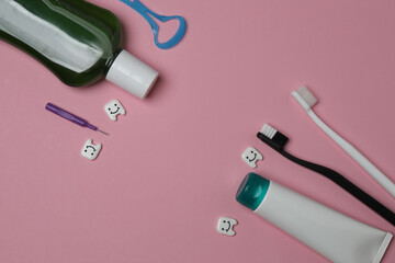 toothbrush, toothpaste, dental floss, tooth rinse on a pink background
