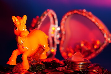 A statuette of a funny horse, coins and decorative ornaments.
