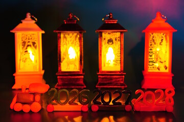 A small train made of plasticine with the numbers 2026, 2027, 2028 and Christmas lanterns.