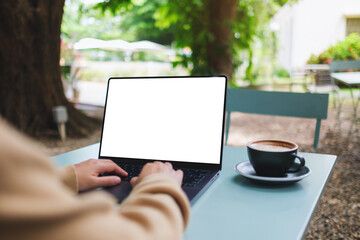 Mockup image of a woman working and typing on laptop computer with blank white desktop screen in...