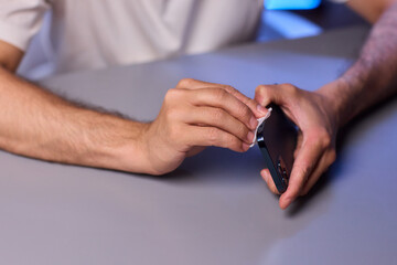 Cleaning a smartphone screen with a tissue needs attention for optimal hygiene and care