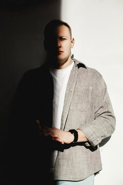 Man in shadow and light against white wall