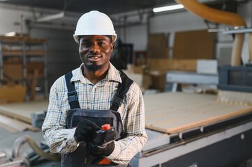 Furniture maker operating cnc machine in factory