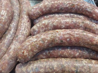Fresh raw sausage links ready for grilling, perfect for barbecues or hearty family meals. Top view. 