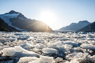Glacier ice fragments blanket a lake, mountains rise in the background bathed in sunlight