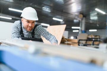 Carpenter working on wood panel in furniture factory