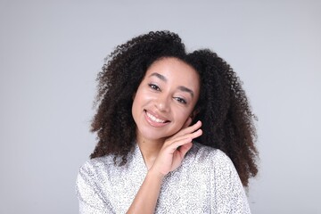 Beautiful Brazilian woman with healthy skin on gray background