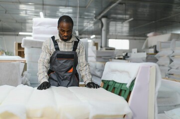African american Furniture maker working on sofa manufacturing in upholstery workshop
