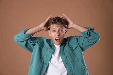 Portrait of surprised man on brown background