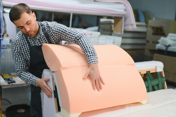 Furniture maker assembling sofa in upholstery workshop