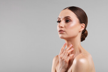 Portrait of beautiful young woman on gray background, space for text