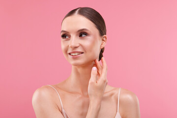 Portrait of beautiful young woman on pink background