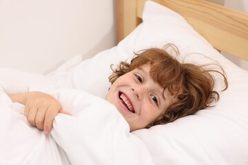 Little boy lying in bed at home