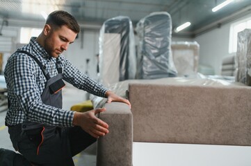 Skilled worker assembling sofa in furniture factory