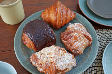 Close up Butter plain, Macadamia and Almond croissants served with Pain au Chocolat- yeasted puff pastry dough wrapped around a stick of chocolate