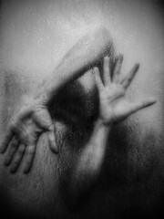 Silhouette behind foggy glass, hands pressed, emotional tension.