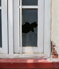 A window with a leaf in it and a crack in the glass