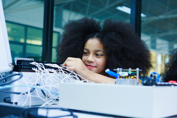 African American girl assembling electronic components in STEM lab, showcasing hands-on learning,...