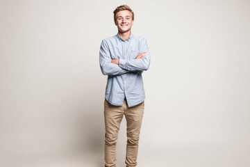 Fototapeta premium Happy smiling young man standing with arms crossed wearing casual shirt and pants.