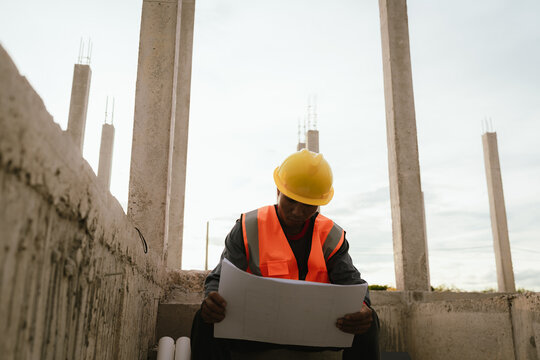 Frustrated male construction engineer wearing a hard hat looks stressed and overwhelmed at a job site, facing work pressure, safety concerns, and occupational burnout challenges. - Powered by Adobe