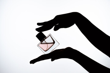 Elegant Silhouette of Hands Holding Perfume Bottle