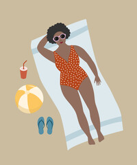 Woman in sunglasses lying on the beach sunbathing.