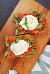 Pair of Freshly Cooked Poached Egg on Fresh Tomato and Basil Wholewheat Toast