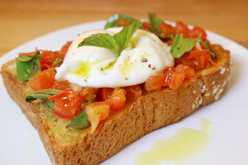 Closeup of Mouthwatering Fresh Tomato and Basil Toast Topped with Poached Egg