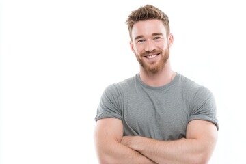 Obraz premium Confident smiling young man with beard in casual grey t shirt standing with crossed arms.