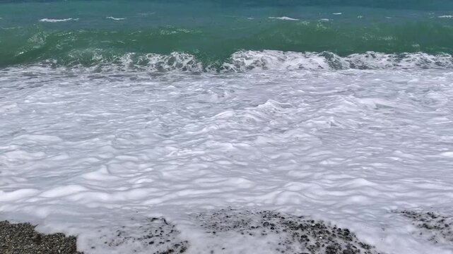Small waves crashing onto a tropical pebble beach - Looc Surigao City Philippines
