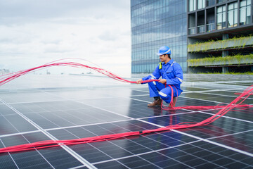 Electrical engineer inspecting and installing a solar panels on the building rooftop.