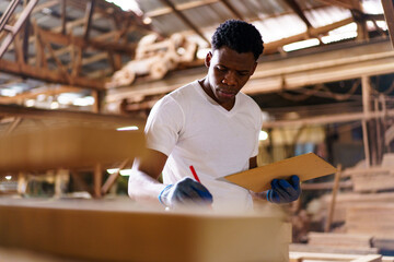 Professional African male carpenter is working professionally in sawmill - workshop.