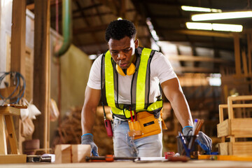Professional African male carpenter is working professionally in sawmill - workshop.