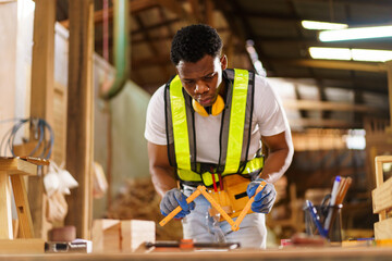 Professional African male carpenter is working professionally in sawmill - workshop.