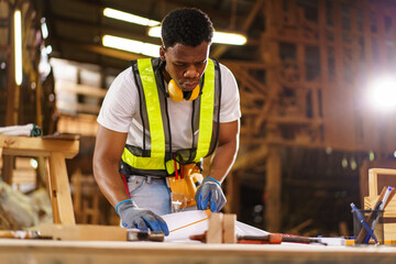 Professional African male carpenter is working professionally in sawmill - workshop.