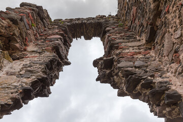 Ruins of tower medieval Hubkiv Castle against cloudy sky, Ukraine