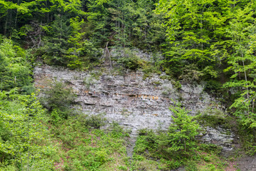 Part of mountain slope with layered structure outcrop of rocks