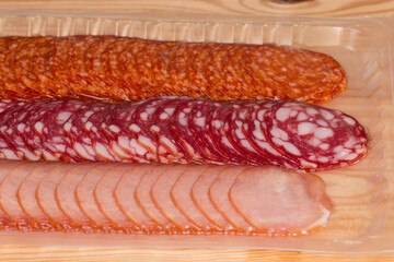 Set of cold meats slices in closed vacuum packing, fragment