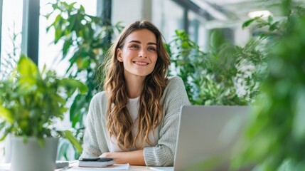 Happy Woman Working on Laptop in Bright Indoor Garden Space with Green Plants.