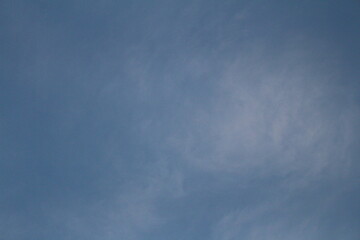 A clear, pale blue daytime sky with wispy, faint clouds scattered across it.