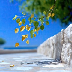 Yellow and Green Leaves Falling from Branch Near Stone Wall