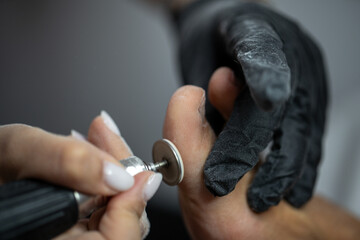 Electric file tool used during professional pedicure procedure to smooth toe skin in beauty salon